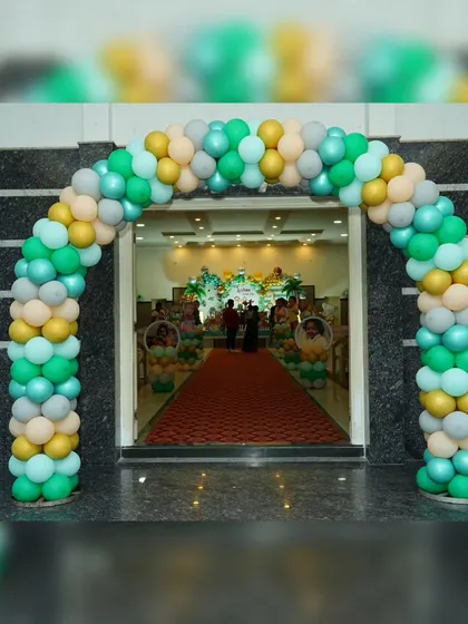 A full view of the entrance to Lochan's jungle party, featuring a beautiful balloon arch in shades of green, yellow, and silver, welcoming guests into the celebration hall.