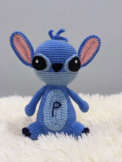 A custom-made Stitch amigurumi, complete with his big ears and mischievous look. This one has the initial 'P' embroidered on his belly for a personal touch.