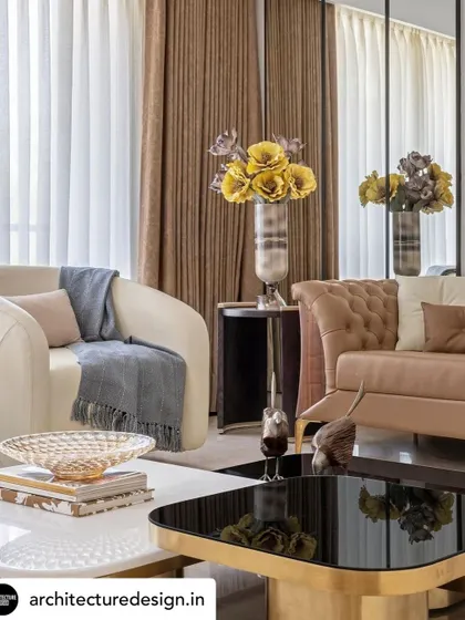 Curated decor and plush furnishings in tones of cream and brown add warmth and texture to the living room. Large windows dressed in dual-layered curtains allow for controlled natural light, enhancing the room's ambient quality.