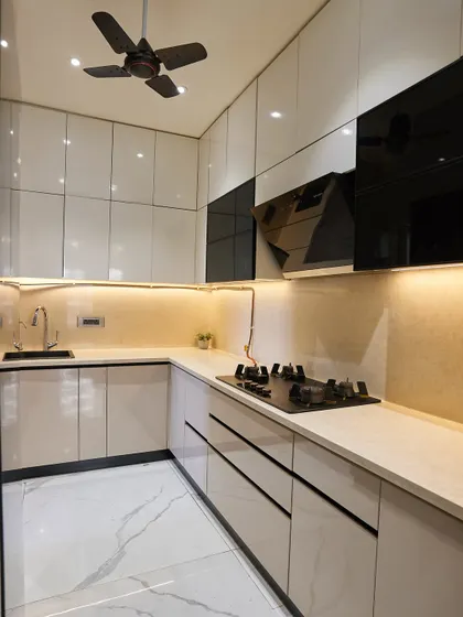 This U-shaped kitchen is a great example of maximizing a compact space. The glossy white and black cabinets create a striking contrast, and the under-cabinet lighting illuminates the workspace perfectly.