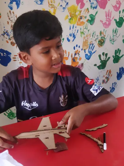 A student works on his F/A-18 fighter jet model, carefully assembling the intricate parts of this famous aircraft.