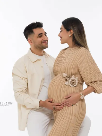 A soft and romantic couple's maternity portrait. The neutral tones and gentle expressions create a feeling of peace and quiet love.