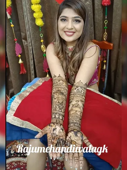 A smiling bride proudly shows off her custom mehendi, which features detailed portraits of her and her groom, telling their unique story.