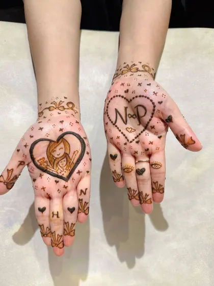 The cutest Teej mehendi, celebrating a mother-daughter bond with a sweet portrait and their initials.