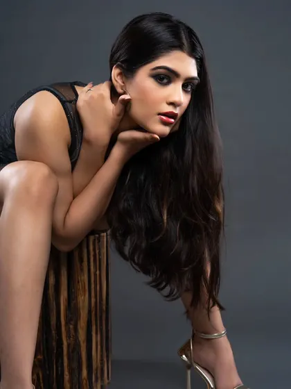 A classic seated portrait from a model's portfolio session. The lighting is soft yet directional, highlighting her features and creating a sophisticated look suitable for both commercial and fashion work.
