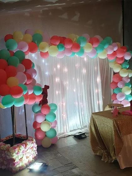 Another angle of Puvi's first birthday, showcasing a hot-air balloon prop made from balloons and a floral base. This creative element adds a unique and whimsical touch to the overall party decoration.