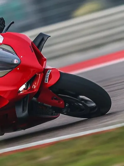A rider on a red Ducati Panigale leans deep into a corner, showcasing the confidence and skill that comes from dedicated track time.