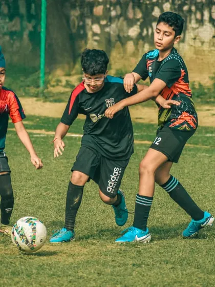 Three players converge on the ball in a display of commitment and hustle.