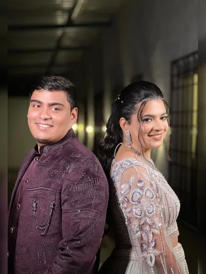 A fun back-to-back pose of the couple, showing off their stylish sangeet outfits.