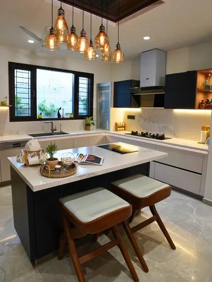 This view shows the two cooking zones: a modern induction hob on the island for Fariha and a traditional gas stove on the main counter for her mother-in-law, catering to different cooking styles.