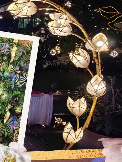 A collage of detailed decor elements, including artistic lotus-shaped lamps and lush green foliage walls, showcasing the variety of textures and materials I use.