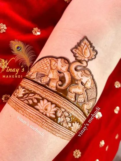 A charming arm band design featuring two elephants with their trunks raised, a symbol of good luck. The lotus motifs add a touch of grace and purity.