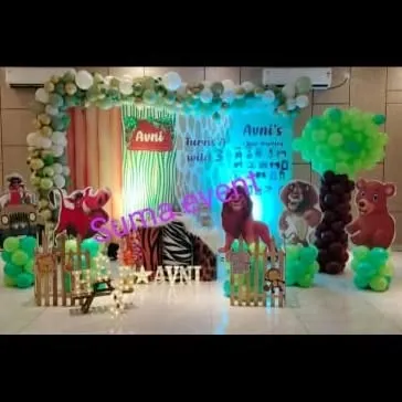 A "Wild" jungle-themed party for Avni's 3rd birthday. This setup features character cutouts from The Lion King, balloon trees, and a backdrop with zebra and leaf prints to create a fun safari vibe.
