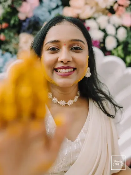 A playful and interactive shot, with a hand covered in Haldi reaching towards the smiling bride. It’s a fun, candid moment that feels personal and engaging.