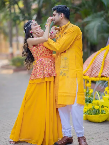 A playful moment from a Haldi ceremony, with the bride cheekily putting some turmeric on the groom's nose.