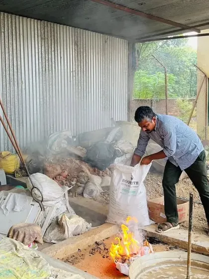 Preparing the reduction chamber for Raku. We use combustible materials like sawdust or newspaper, which ignite when the hot pottery is placed inside, creating a smoky, oxygen-starved atmosphere for the glazes to develop.
