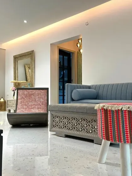 A closer look at the living area in the Bandra Bohemian house. The carved details on the sofa base, patterned poufs, and ornate mirrors all contribute to a layered, free-spirited interior design.