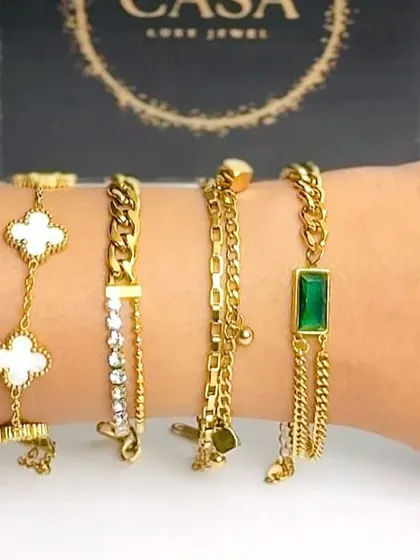 A detailed wrist shot displaying a variety of chain and charm bracelets against the product's packaging. This helps customers see the scale and detail of each piece up close.