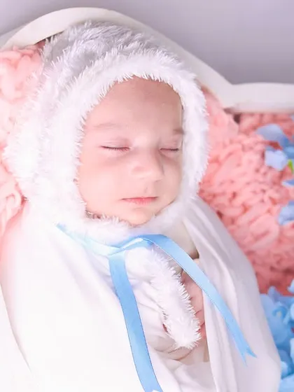 A tight close-up on the baby's face, showing the delicate features and the softness of the bunny bonnet.