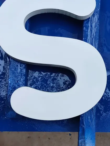 A close-up showing the smooth, flawless surface of a letter after receiving its Duco finish.