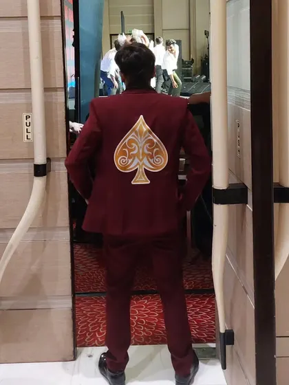 The moment before I step on stage at the Red Chief event. My custom-designed jacket with the spade symbol sets the tone for a unique and stylish performance.