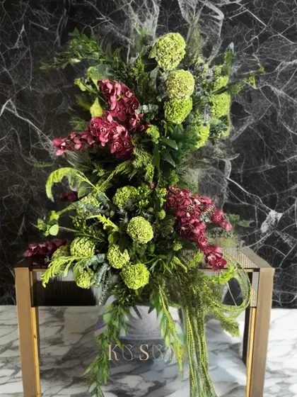 I call this one the "Dancing Ballerina." It's a tall, graceful flower installation I designed for the console of a living room, with cascading greens and a beautiful mix of textures.