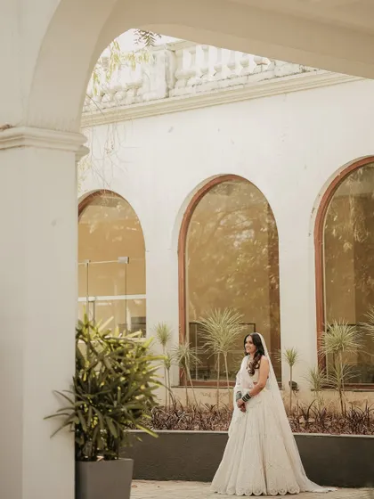 A portrait using the venue's architecture to frame the bride. The repeating arches create a beautiful backdrop, making her look graceful and serene.