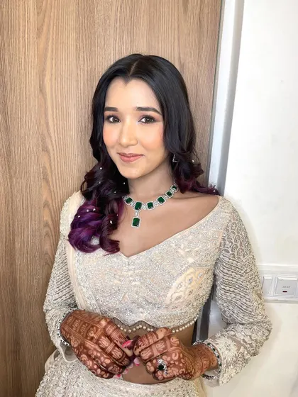 A simple, minimal, and elegant look for the sister of the bride. The pop of purple in her hair adds a fun and unique touch.