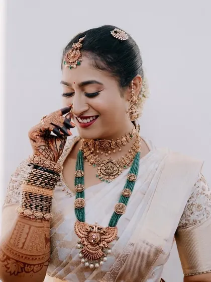 A candid moment of Shilpa's shy smile, with her henna-clad hand adding to the charm.