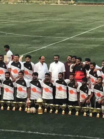 Capturing the moment from a different angle. The team stands proudly with officials and our trophies, representing a significant achievement for the club.