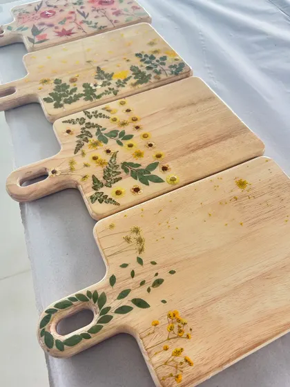 A beautiful collection of wooden chopping boards decorated with pressed flowers and sealed in resin.