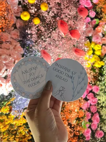 Personalized coasters with a clever pun, "In-shane-ly good times ahead," for Aaliyah and Shane's cocktail party. It's the small, witty details that make an event memorable.