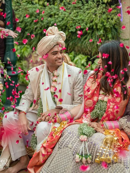 A magical moment as flower petals rain down on the happy couple during their intimate Delhi wedding.