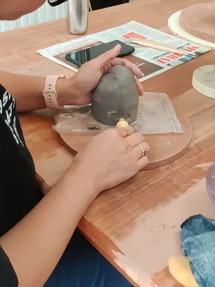 A student carefully carves details into her capsicum sculpture. These focused moments are where the magic happens, as a simple lump of clay begins to take on a life of its own.