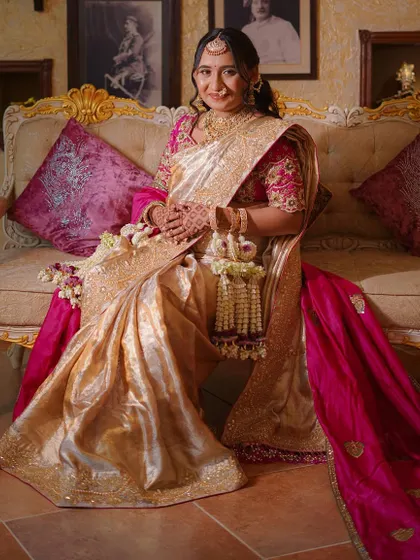 A full-length portrait of the expectant mother. The fresh white and purple flowers in her kalire add a touch of elegance to her beautiful saree.