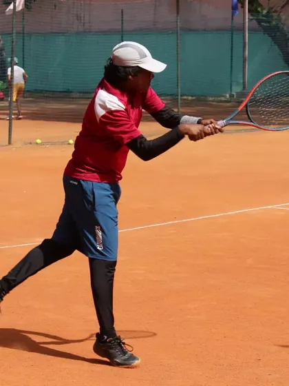 A player hitting a two-handed backhand with excellent form. Our technical coaching covers all aspects of the game, ensuring a well-rounded skill set.