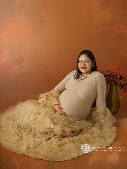 A lovely seated portrait where the cascading ruffles of the gown create a stunning visual. The warm tones and soft lighting make for a very inviting image.