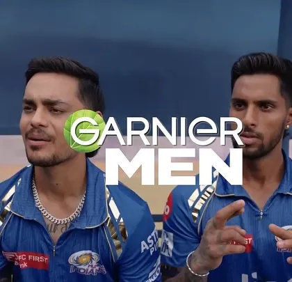 A close-up of two Mumbai Indians players from the Garnier Men commercial. The focus is on their interaction, with their team jerseys providing the context.