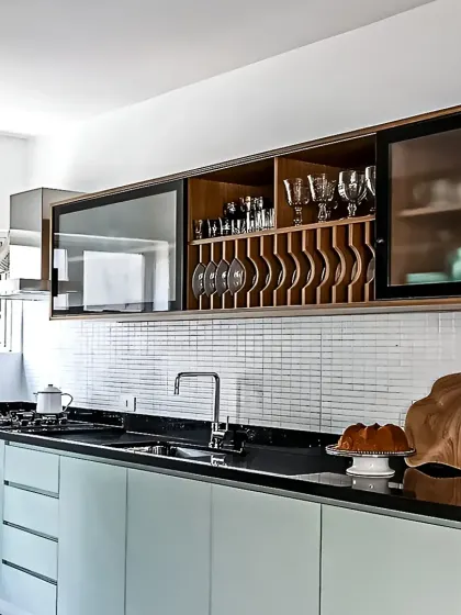 A unique upper cabinet design with integrated wine and glass storage. The mint green base cabinets and mosaic tile backsplash complete this stylish look.