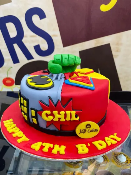 A 1.5kg superhero mashup cake, split between Batman, Superman, and the Hulk.