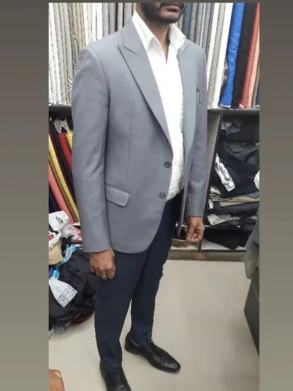 A client wearing a light grey blazer I tailored for him. It's paired with navy trousers for a classic smart casual look, ideal for office wear or social gatherings.