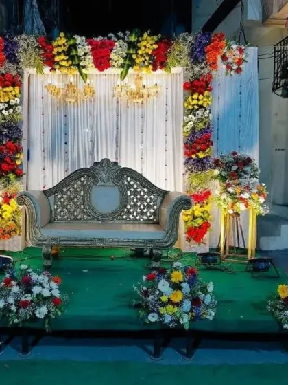 Another view of the multi-colored floral stage, showing the full arch and seating arrangement.