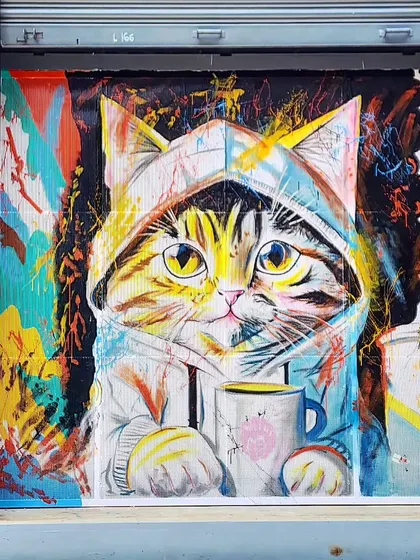 A full shot of the enamel mural for Meows & Muffins, featuring a cute cat surrounded by a storm of vibrant, abstract colors.