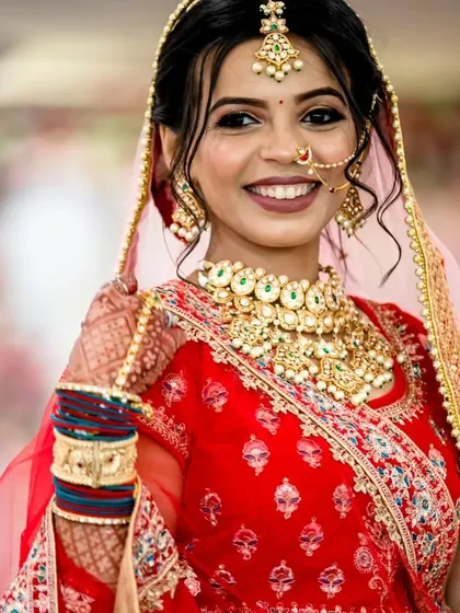 Another shot of this radiant bride. The Kundan choker with its light green stones perfectly complements her red lehenga.