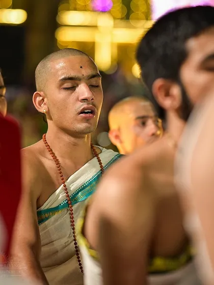 A young pandit chants with closed eyes during the Maha Shivratri celebration. The devotion and focus of the chanters contribute significantly to the divine atmosphere of the event.