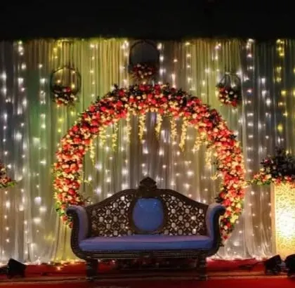 A simple yet magical wedding reception decor with a floral ring backdrop and a curtain of fairy lights.