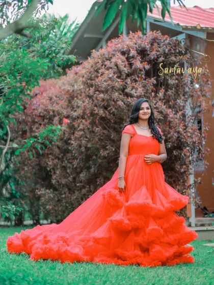 This vibrant red frill gown looks stunning against the green lawn of a beautiful resort-style location, showcasing an option for a grand outdoor shoot.