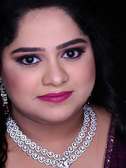 A bold and beautiful engagement look. The makeup features a dramatic purple smokey eye that makes a statement, paired with a bright pink lip and a stunning diamond necklace.