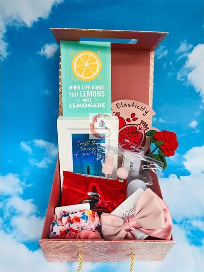A bright and cheerful gift box designed to inspire. It includes a "When life gives you lemons, make lemonade" notebook, a framed quote, and various cute accessories.
