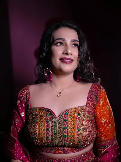 A portrait of the bride looking away with a thoughtful smile. The rich, colorful embroidery of her blouse is a beautiful detail in this shot.